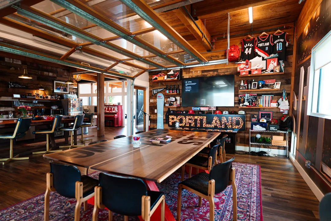 TEDxPortland HQ: long communal table beneath the neon PORTLAND sign