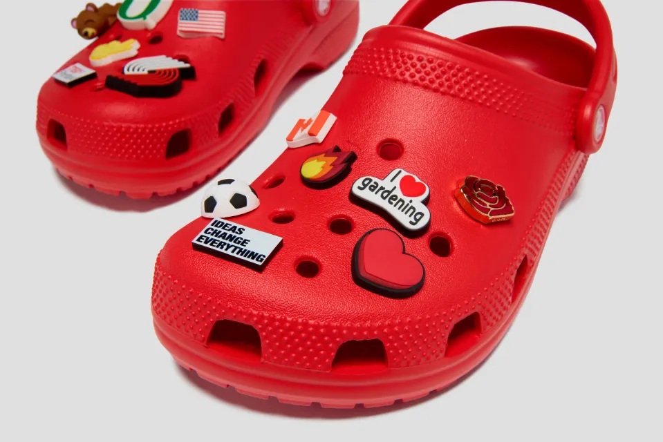 Close-up of a red Crocs × TEDxPortland clog with "Ideas Change Everything" and "I love gardening" Jibbitz