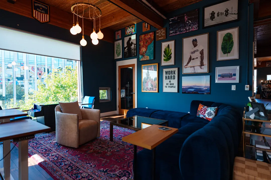 TEDxPortland HQ: navy sectional sofa and gallery wall beside a bright window